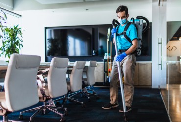 ServiceMaster Clean janitor vacuuming an office conference room