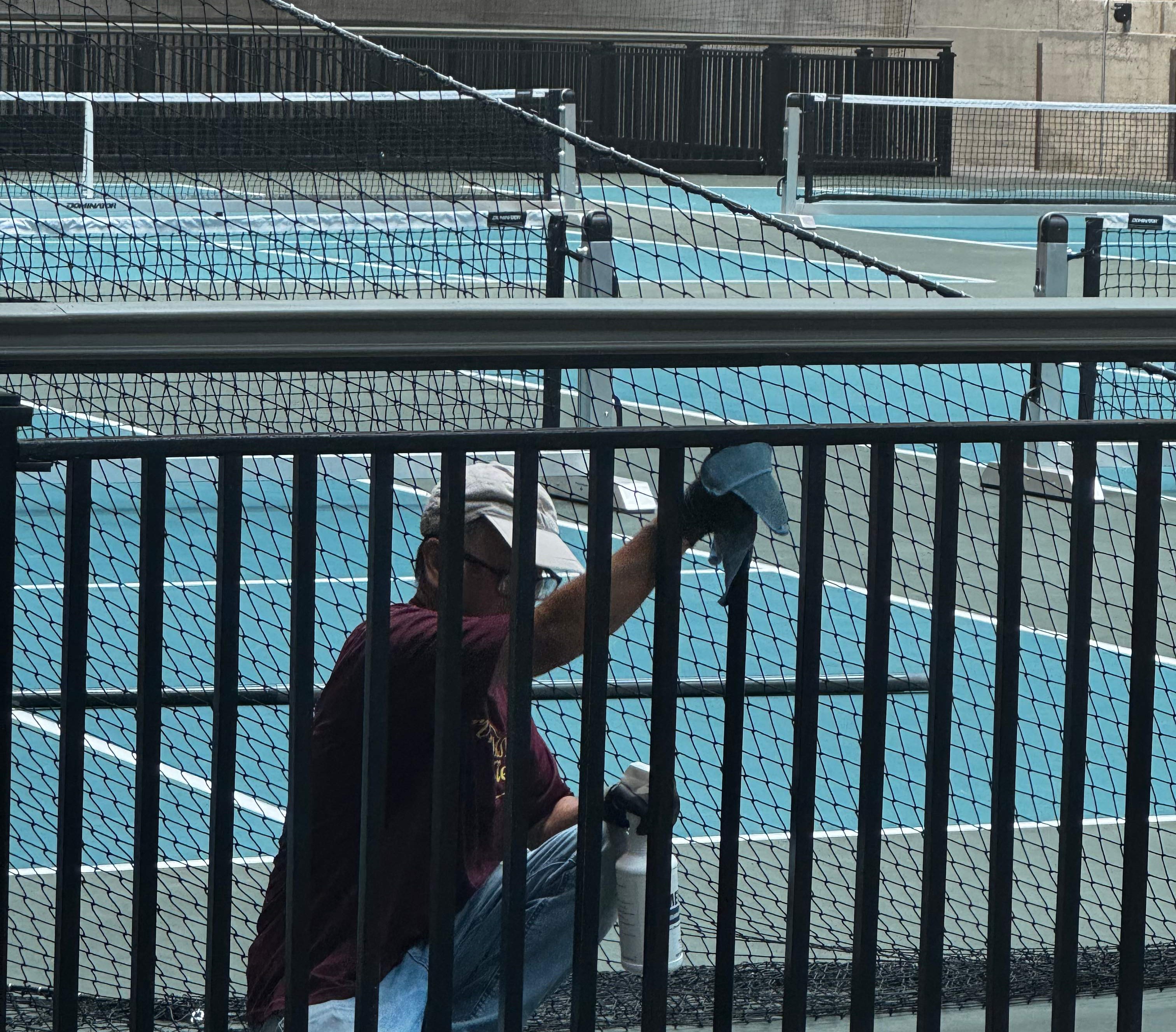 A person painting a tennis court
AI-generated content may be incorrect.