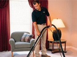 A ServiceMaster Clean employee vacuuming a living area in an assisted living facility in Carol Stream