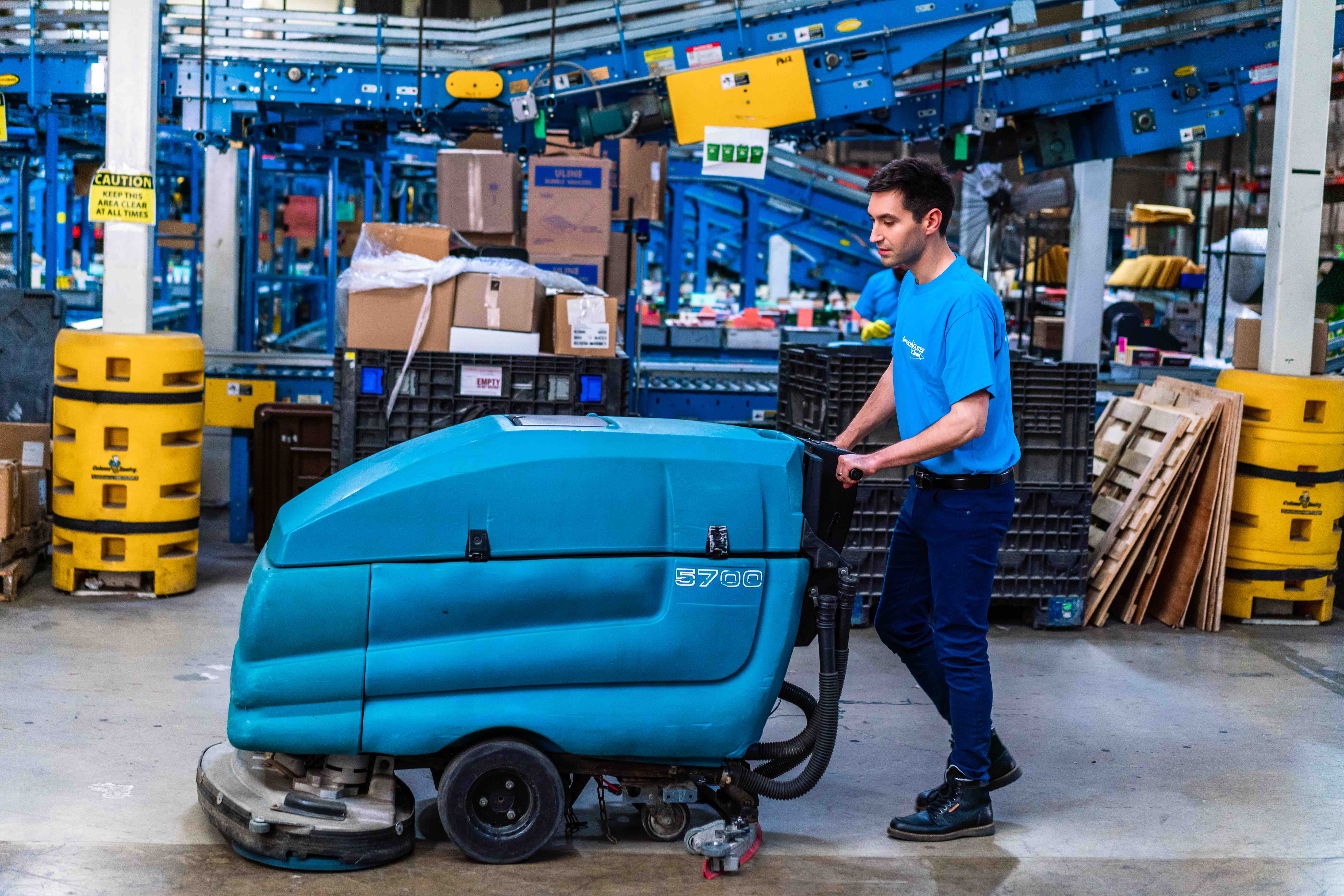 man buffing floor in warehouse