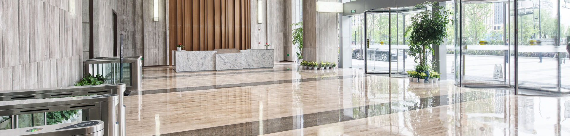 An large office building foyer with freshly cleaned floors and wiped down glass walls