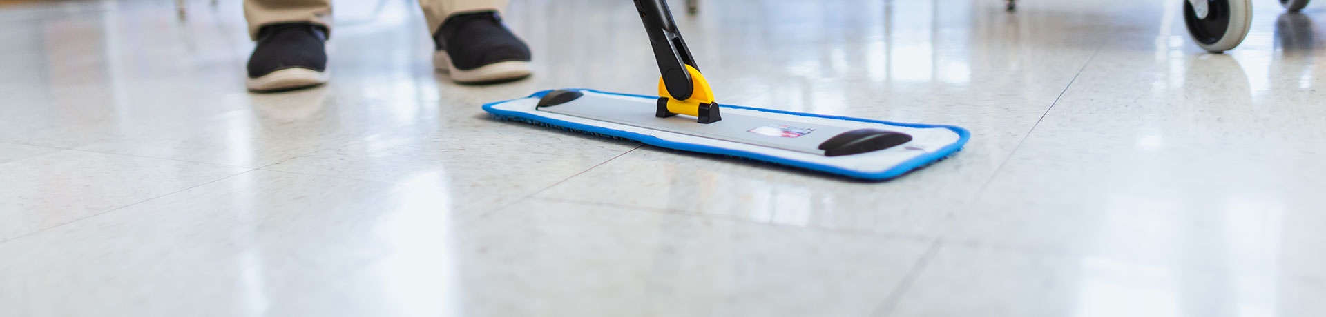 Industrial laminate flooring being wiped clean with a microfiber sweeper