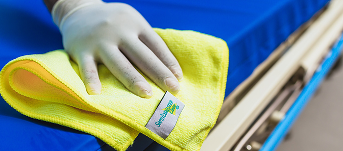 A ServiceMaster expert wiping down equipment in a healthcare facility during commercial cleaning