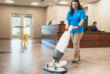 woman mopping floor of a lobby area in a houston office