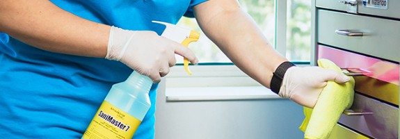 A ServiceMaster Clean expert sprays and wipes down a filing cabinet during commercial cleaning services in Mankato, Minnesota