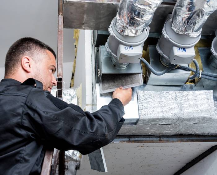 image of a man cleaning an air duct