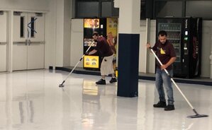two servicemaster clean employees cleaning linoleum floor
