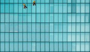 men cleaning windows on the side of a building