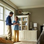 Two people standing in a living room