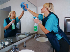 woman wiping bathroom mirror