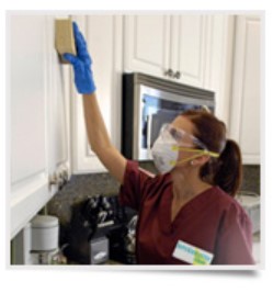 Woman scrubbing cabnets with sponge