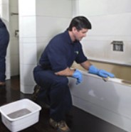 a man cleaning a bathroom with fire damage
