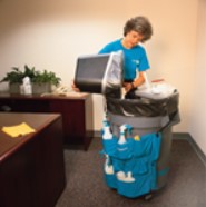 woman dumping trash can in larger trash can